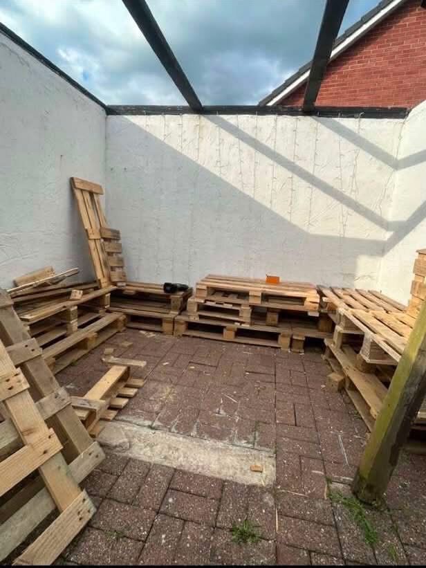 Before: bare pallets laid out in an empty corner patio